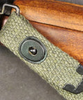 Close-up of M1 Carbine Web Sling OD Green One Inch Canvas Reproduction With Lift-The-Dot Closure attached to rifle.