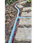 Soft Infiltration Perforated Drainage Pipe For Underground Landscaping And Water Management installed in garden soil with stone path