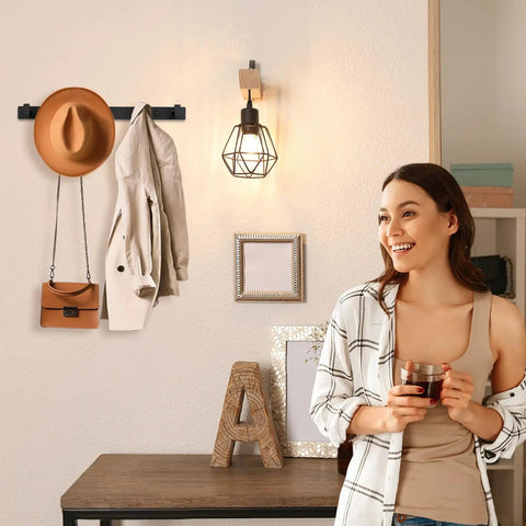 Sturdy Matte Black Wall Mount Coat Rack With Five Heavy Duty Metal Hooks, rustproof, holding coat and hat in a modern entryway.