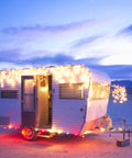 100 Count Mini Clear Christmas Lights On 21 Feet White Wire For Indoor Outdoor Decor lit up along camper at sunset.