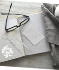 All In One Eyeglasses Repair Kit With Silicone Nose Pads, Mini Screwdrivers, Tweezers And Tiny Screws displayed on a book.