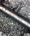 Close-up of a metal axle coated with Graphite Dry Lube For Wood Derby Cars With Tungsten Moly Boron Blend.