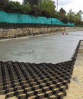 Heavy-Duty Gravel Grid Stabilizer for Driveways and Pathways being installed on a residential entrance, honeycomb paver system visible