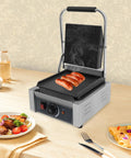 1800W Commercial Panini Grill Press With Stainless Steel Body And Cast Iron Plates cooking sausages on countertop.
