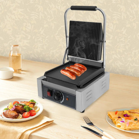 1800W Commercial Panini Grill Press With Stainless Steel Body And Cast Iron Plates cooking sausages on countertop.