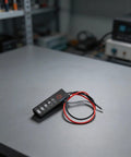 Straight Up Led Battery Voltage Gauge 5V To 21V with wires on gray workbench for checking lithium cell voltage.