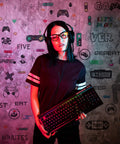 Person holding keyboard in front of wall with White And Black 56 Piece Gamer Wall Decal Set With Controllers And Joysticks