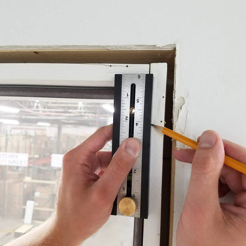 Person using the Straight Shooter Nine In One Measuring And Marking Tool featuring dual levels against a wall to mark measurements.