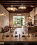 Textured Pendant Light, Cream Aesthetic Hanging Lamp for Kitchen Island above a cafe setting with wooden beams and plants.