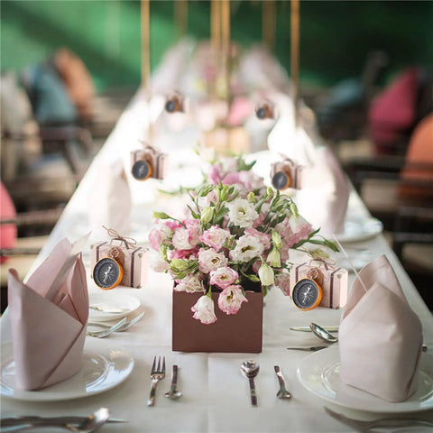 50 Pack Candy Boxes With Compass Gift Sets displayed on wedding table with flowers and rose gold compass theme