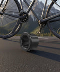 Thru Axle Nut M15x1.5mm Black Hub Cap for Front and Rear Wheels with a bike in the background on a road