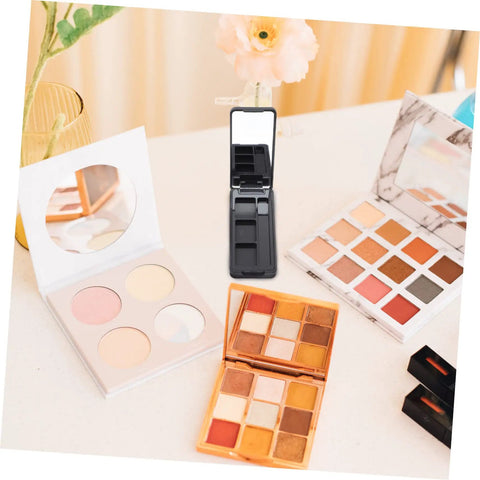 Dope New Compact Travel Makeup Palette With Mirror, Four Pack Empty Eyeshadow Containers For Portable Cosmetic Refills And Fly On The Go Beauty Organizers on a table.