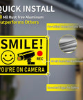 Close-up of a 'Smile You're On Camera' sign with CCTV graphic, 10x7 rust-free aluminum, outdoor video surveillance warning sign.