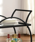 Close-up of Modern Black Two Tier Bar Cart With Mirror Trim And Metal Frame, featuring stacked plates and drink bottles.