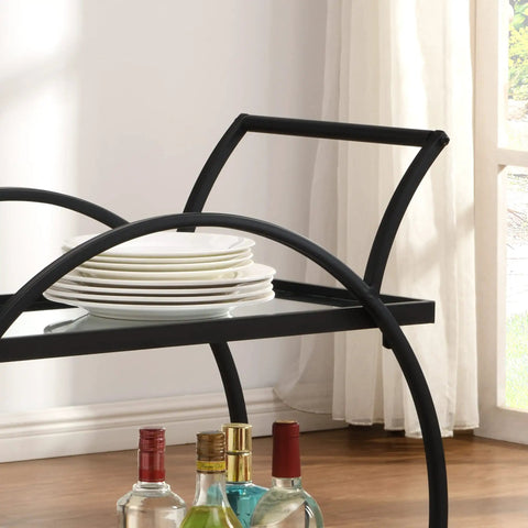 Close-up of Modern Black Two Tier Bar Cart With Mirror Trim And Metal Frame, featuring stacked plates and drink bottles.