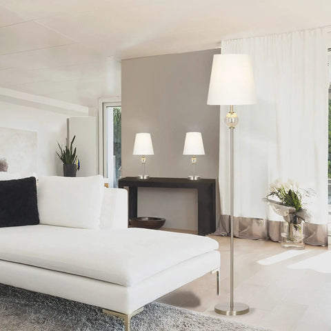 Transitional 3 Piece Table And Floor Lamp Set With Glass Font Detail, 58 Inch Floor Lamp And Two Table Lamps, Brushed Nickel Finish, White Linen Drum Shades, Lit Mood And Task Lighting For Living Room Or Office in a modern living room setting.