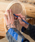 Round center finder circle gauge in use on wood to draw circles; clear acrylic drawing template, 300 mm.