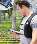 Man wearing High Visibility Reflective Running Vest Hydration Backpack Plus 500ml Soft Flask outside holding tablet