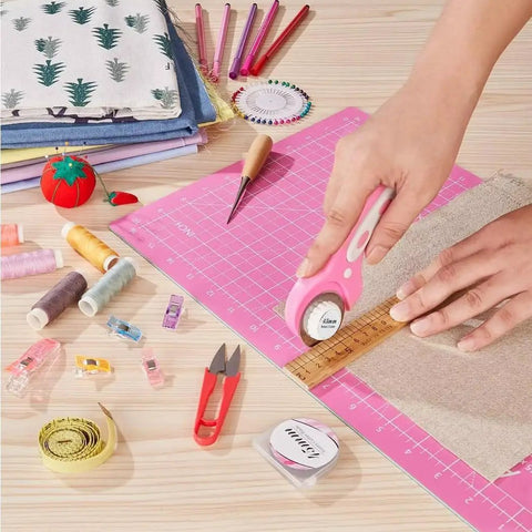 45mm Rotary Cutter With 5 Extra Blades, Ergonomic Grip, Safety Lock, The Real Deal For Fabric Leather Crafting Sewing And Quilting, Cuts Through Multiple Layers Like Butter, Left Or Right Hand, Pink, cutting fabric on a pink mat with sewing tools