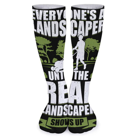Knee-high socks with landscaper design, text "Everyone's a landscaper until the real landscaper shows up," green and black print.