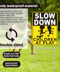 Slow Down Children At Play Safety Signs 2 Pack 17 By 13 Inch Double Sided Corrugated Plastic with H Metal Stakes displayed on grass.