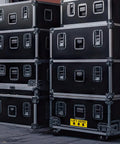 Lift Here label decal on black flight cases; bright yellow with black text and down arrows