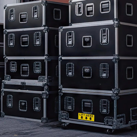 Lift Here label decal on black flight cases; bright yellow with black text and down arrows