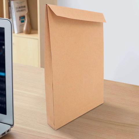 Kraft Self Seal Mailing Envelopes 238x335x40mm With Double Sided Adhesive Tape on a desk beside a laptop