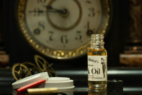 Pro Grade Clock Oil Kit For Cleaning And Lubing Movements, glass bottle of clock oil with clock parts and vintage clock face