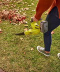 Person using No Sweat Heavy Duty 18V Cordless Yard Leaf Blower With Comfy Overmold Grip to clean leaves on grass.