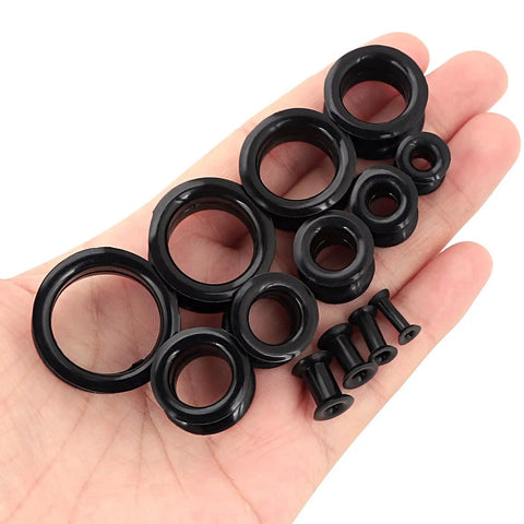 Hand displaying 26 Piece Silicone Ear Tunnels Set 8G To 1 Inch Hollow Flexible Soft Ear Stretching Kit for sleeping, sports, and daily wear.