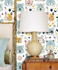 Slick Pastel Woodland Peel And Stick Wallpaper With Cute Animal Head Prints in a cozy bedroom setting with lamp and decor.