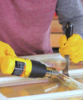 Person using Dual Temp Heat Gun Kit With 750 Degrees F And 1000 Degrees F, Three Nozzles Included, DIY-Friendly For Home Projects, Ideal For Shrink Wrap, Softening Paint, Bending Plastic Pipes, Loosening Rusted Bolts And More to remove paint from a window frame.