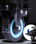 Close-up of a black caster wheel with blue trim featuring 360° rotation and integrated brake switch for the 24 Inch Straight Up Heavy Duty Industrial Electric Floor Fan Rolling On Caster Wheels For Built Like A Tank Durability And Kickin Up Major Workshop Warehouse Cooling Performance.