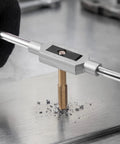 Person using Beefy Titanium Coated Steel Tap And Die Set for threading metal with a wrench on a steel surface.