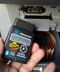 Bluetooth OBD2 Scanner For Cars With Real Time Diagnostics Read And Clear Engine Fault Codes Wireless Code Reader Tool Pro Grade Auto Diagnostic Adapter For Universal Vehicle Compatibility And Easy Car Troubleshooting held in hand near car port