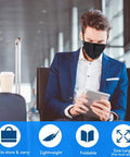 Man in airport lounge wearing KN95 Black Face Masks Pack Of 30 With 5 Layer Filtration Over 95 Percent Efficiency