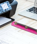 3 Hole Punch For Ring Binders With Built In Ruler on wooden desk near laptop and printer, deep pink ABS plastic, stainless steel punch heads