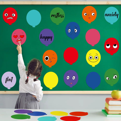 Child pointing at colorful balloon cutouts on a classroom bulletin board, each with a different emotion, from Colorful Balloon Cutouts For Classrooms And DIY Projects, 108 Assorted Hot Air Balloon Die-Cuts With 120 Glue Points, Perfect Bulletin Board Decor For Teachers, Kids Crafts, Wall Art And Classroom Displays.