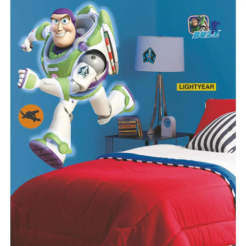 Buzz Lightyear Glow In The Dark Giant Peel And Stick Wall Decal in kids room over blue wall beside bed with red blanket