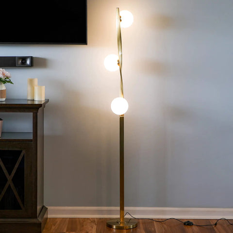Nola Mid Century Modern 3 Globe Floor Lamp For Living Room And Office in gold finish, standing next to a console table.