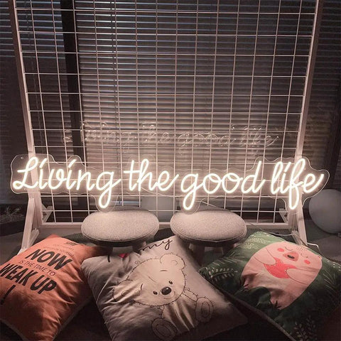 Living The Good Life LED Neon Sign Custom Personalized Home Wall Decor Large 30 Inch Indoor Light with cushions and chairs.