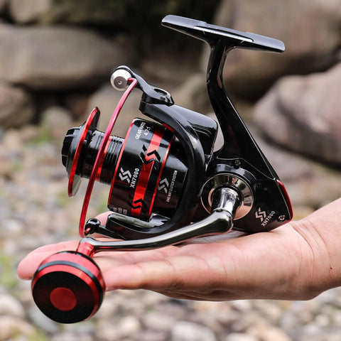 Person holding Red 7000 Spinning Fishing Reel With Ultra Smooth Action 12 Ball Bearings Instant Anti Reverse Beefy Power