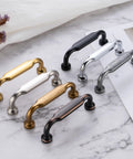 Assorted cabinet pulls on marble background, showing various finishes but focusing on Ten Pack Antique Brass Cabinet Pulls With Three And Three Quarters Inch Hole Centers For Cabinets Drawers Dressers And Vanities Heavy Duty Solid Metal Hardware With Included Screws In Size One Inch And One And One Half Inches.
