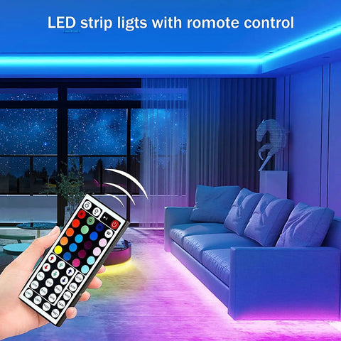 Remote control for 32.8ft Bluetooth RGB LED Strip Lights With Music Sync illuminating a modern living room with blue and purple glow.