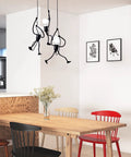 Swinging Man Pendant Light Fixture With Three Black Industrial Arms A Statement 3 Light Chandelier in kitchen dining area