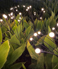 10 LED Starburst Solar Firefly Lights For Outdoors With Swaying Motion in garden, glowing warm white among lush green leaves