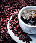 Cup of Turkish coffee being poured over beans, representing Turkish Coffee Ground 100 Percent Arabica Dark Roast Lebanese Arabic Style Beans.