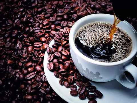 Cup of Turkish coffee being poured over beans, representing Turkish Coffee Ground 100 Percent Arabica Dark Roast Lebanese Arabic Style Beans.
