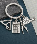 Engineer Keychain Set With Geometry Charm And Measuring Tools, featuring mini triangle ruler, calculator, compass, and tape in gunmetal.